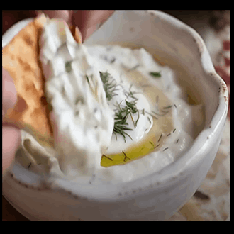 A chilled bowl of traditional Turkish cacık yogurt dip with finely diced cucumbers and dried mint